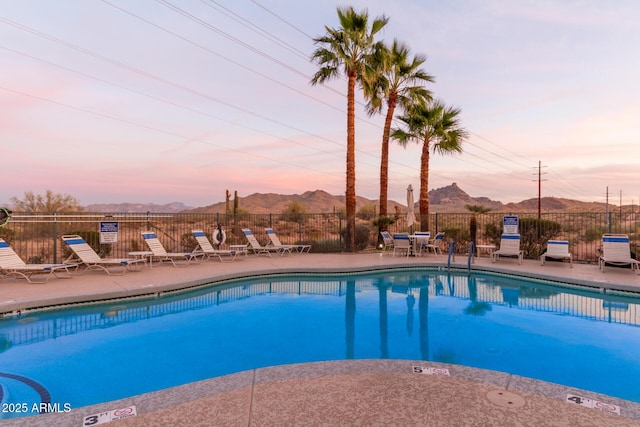 pool with a mountain view, a patio, and fence