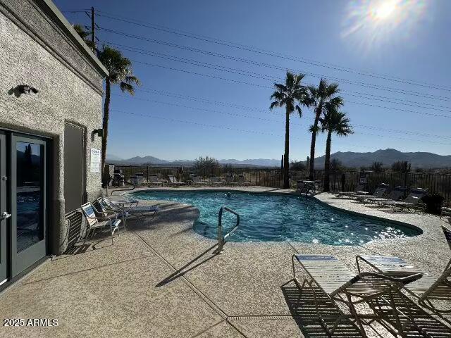 pool with a patio area, a fenced backyard, and a mountain view