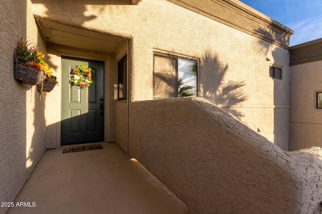 entrance to property featuring stucco siding