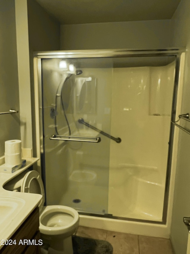 bathroom with toilet, vanity, tile patterned floors, and a shower stall