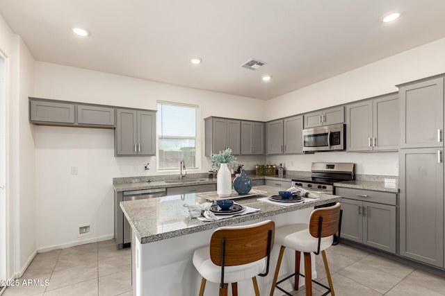 1879 W 23rd Ave, Apache Junction, AZ 85120 - kitchen featuring appliances with stainless steel finishes, gray cabinetry, a center island, a kitchen bar, and recessed lighting