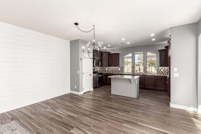 kitchen with a center island, dark wood-type flooring, appliances with stainless steel finishes, and tasteful backsplash