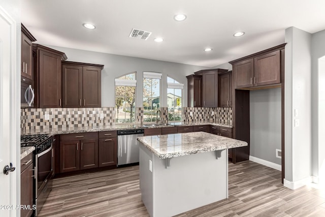 kitchen with a center island, sink, light hardwood / wood-style floors, and stainless steel appliances