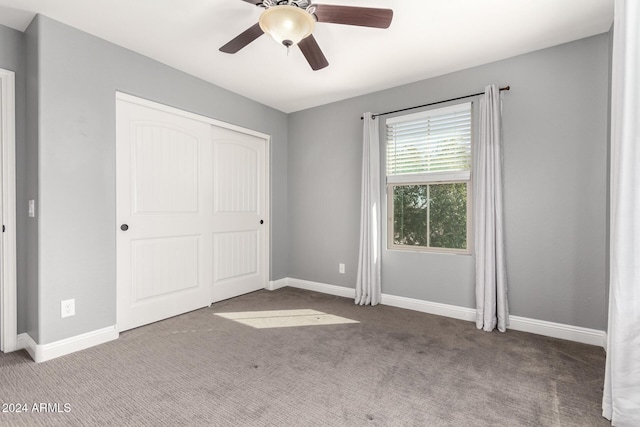 unfurnished bedroom with carpet flooring, ceiling fan, and a closet