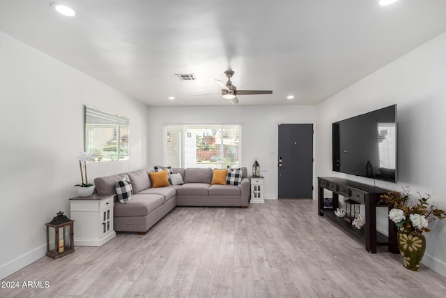 living room with light hardwood / wood-style flooring and ceiling fan