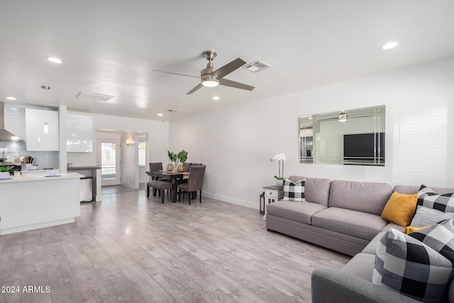 living room featuring ceiling fan and light hardwood / wood-style floors