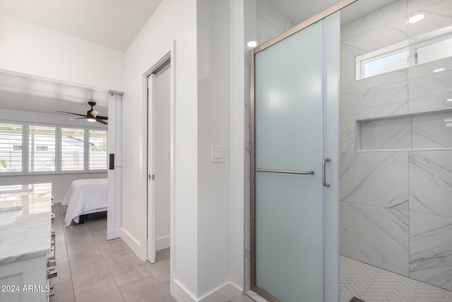 bathroom with tile patterned floors, ceiling fan, vanity, and a shower with shower door