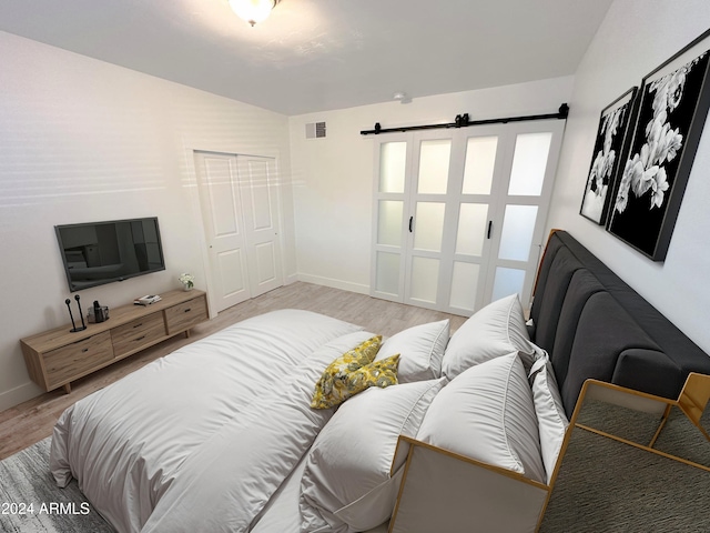 bedroom with light wood-type flooring and a closet