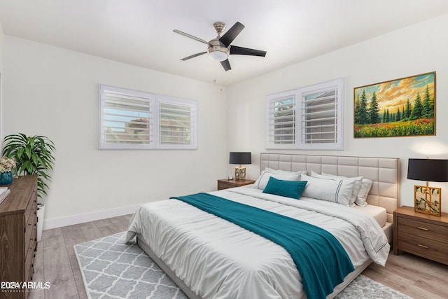 bedroom with light hardwood / wood-style floors, multiple windows, and ceiling fan