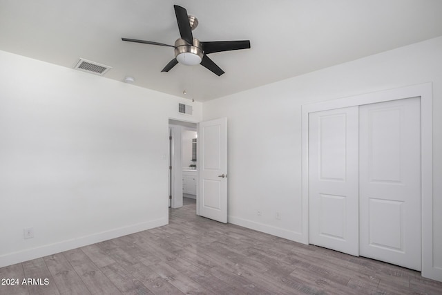 unfurnished bedroom featuring ceiling fan, a closet, and light hardwood / wood-style flooring