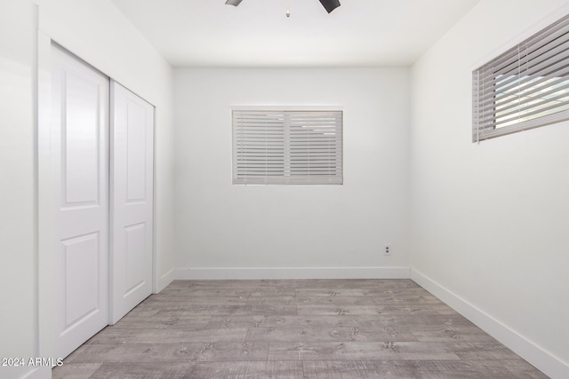 unfurnished bedroom with light wood-type flooring, a closet, and ceiling fan