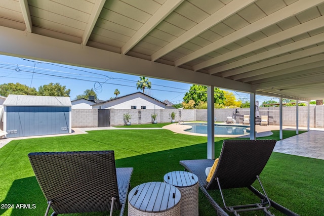 view of yard with a fenced in pool, a shed, and a patio area