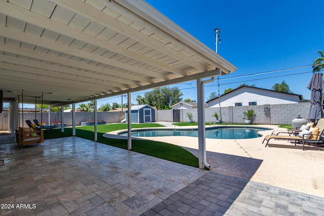 view of swimming pool featuring a shed, a patio area, and a lawn