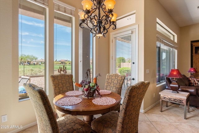 dining room with an inviting chandelier, light tile patterned floors, and baseboards
