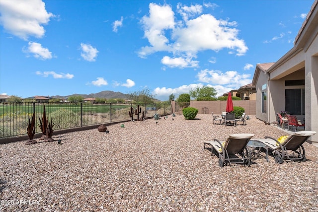 view of yard with a fenced backyard, a patio area, and a mountain view