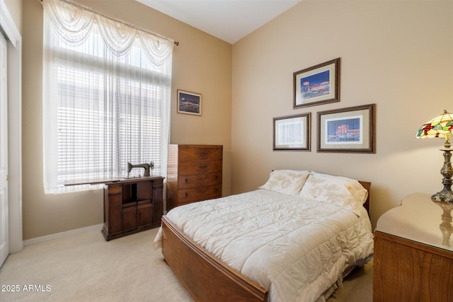 bedroom featuring baseboards and light colored carpet