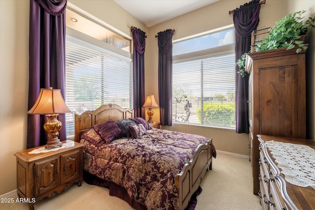 bedroom with baseboards, multiple windows, and light carpet