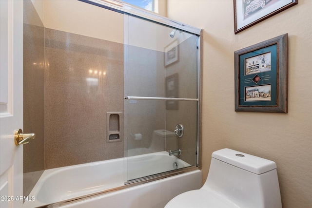 bathroom featuring toilet and combined bath / shower with glass door