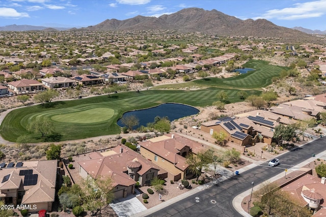 aerial view featuring view of golf course, a residential view, and a water and mountain view
