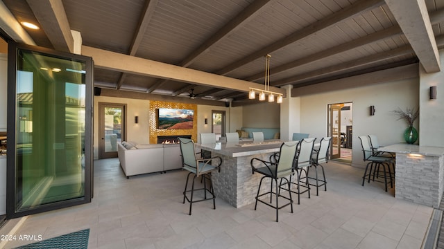 view of patio with ceiling fan and a bar