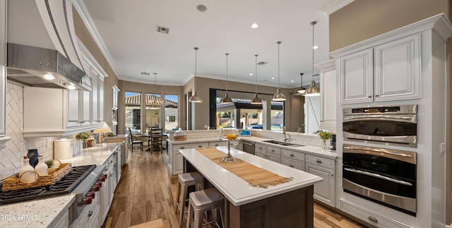 kitchen with pendant lighting, kitchen peninsula, tasteful backsplash, a kitchen bar, and white cabinetry