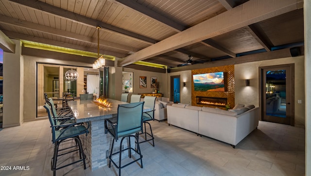 dining space with beam ceiling, wood ceiling, and ceiling fan with notable chandelier