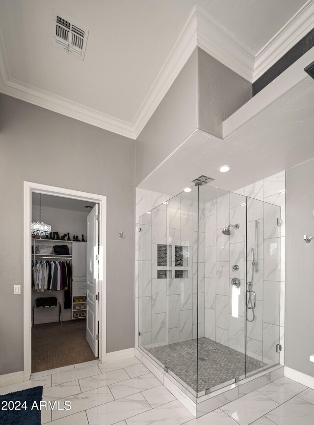 full bathroom with marble finish floor, a shower stall, visible vents, and ornamental molding