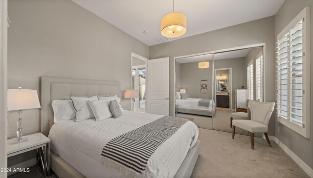 bedroom featuring a closet, light carpet, visible vents, and baseboards