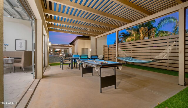 patio terrace at dusk featuring a pergola