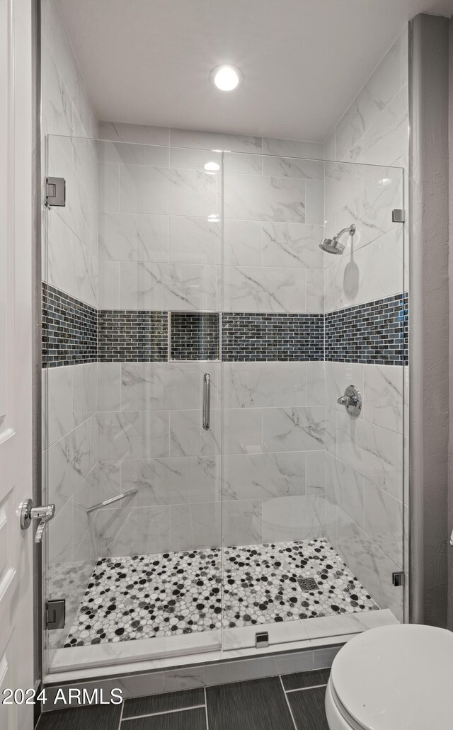 bathroom featuring tile patterned floors, toilet, and walk in shower