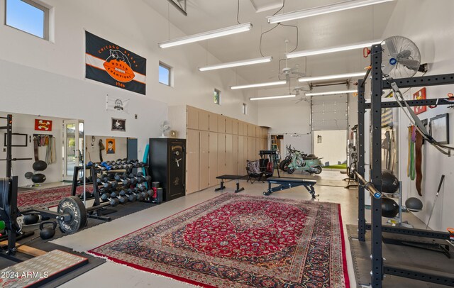 gym featuring a garage and a towering ceiling