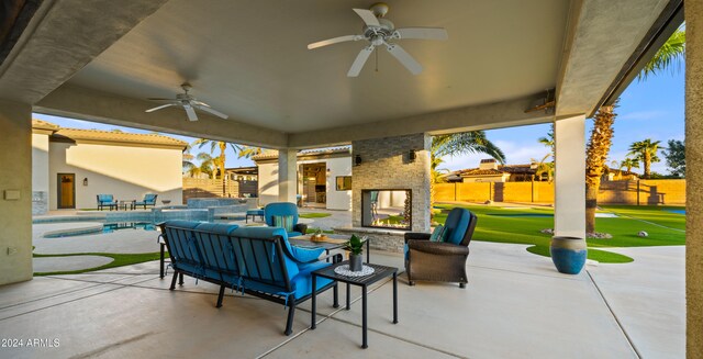 view of patio with an outdoor living space with a fireplace, a fenced in pool, and ceiling fan