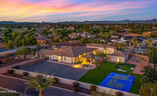 aerial view at dusk featuring a residential view and a mountain view