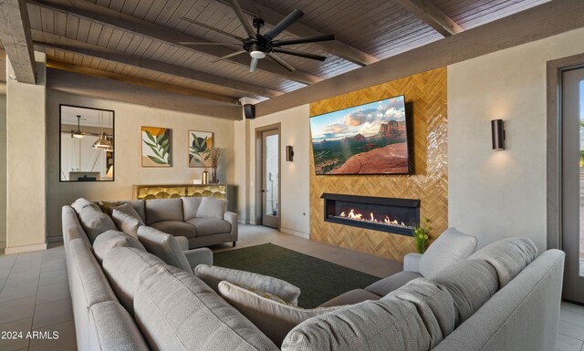 tiled living room featuring wood ceiling, beam ceiling, baseboards, and a tiled fireplace