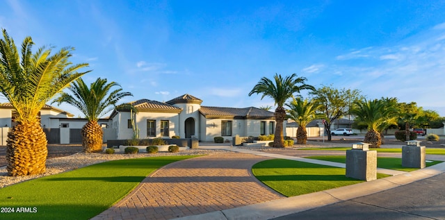 mediterranean / spanish house featuring a tile roof and stucco siding