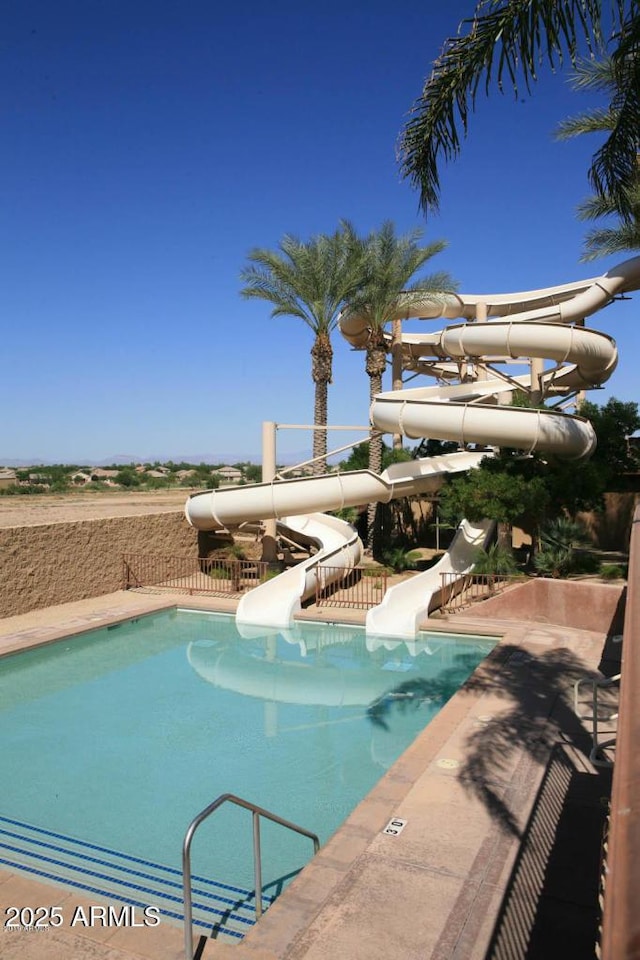 community pool featuring a water slide