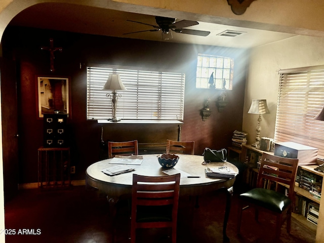 dining room featuring arched walkways, visible vents, and ceiling fan