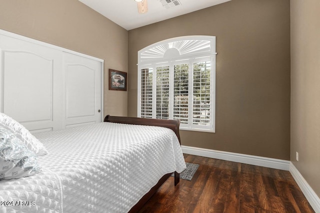 bedroom with a closet, dark wood-type flooring, and ceiling fan