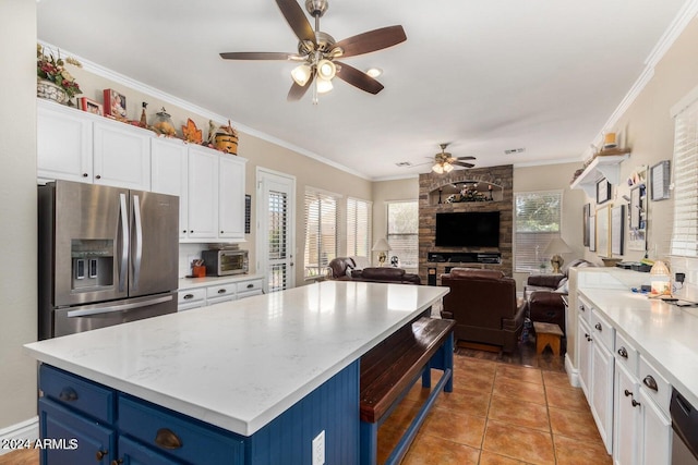 kitchen with blue cabinetry, stainless steel fridge, white cabinetry, and plenty of natural light