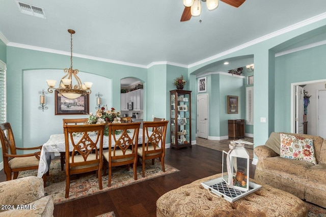 dining room featuring dark wood-type flooring, ceiling fan with notable chandelier, and ornamental molding