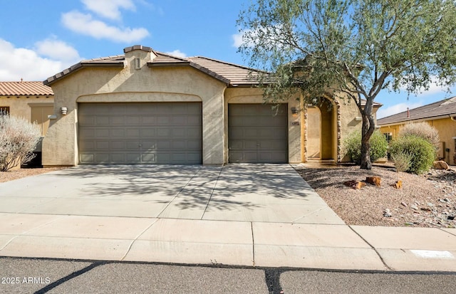 view of front of property featuring a tile roof, driveway, an attached garage, and stucco siding