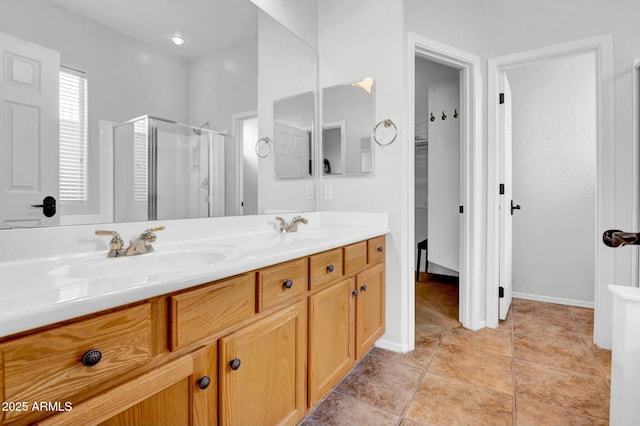 full bathroom featuring double vanity, a shower stall, a sink, and tile patterned floors