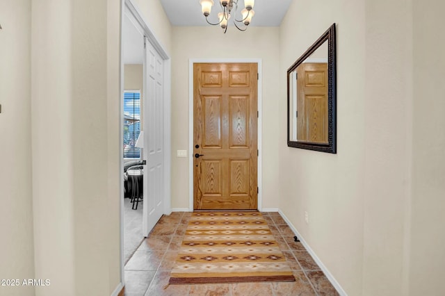 foyer with baseboards, tile patterned floors, and an inviting chandelier