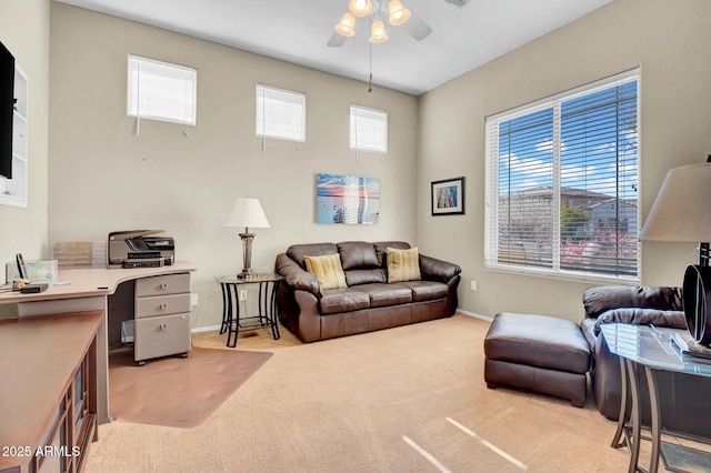 living room with baseboards, a ceiling fan, and light colored carpet