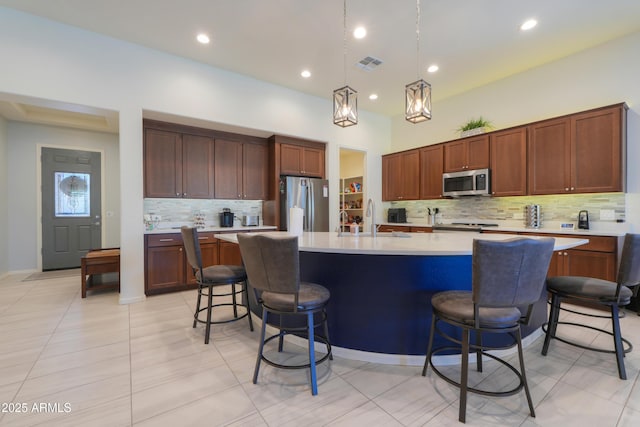 4576 W Agave Ave, Eloy, AZ 85131 - kitchen with appliances with stainless steel finishes, light countertops, a center island with sink, and a kitchen bar