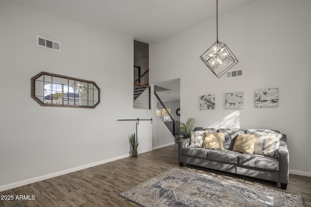 living room with a towering ceiling and dark hardwood / wood-style flooring