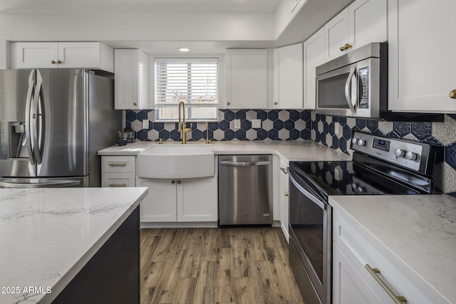 kitchen with white cabinetry, sink, backsplash, and appliances with stainless steel finishes