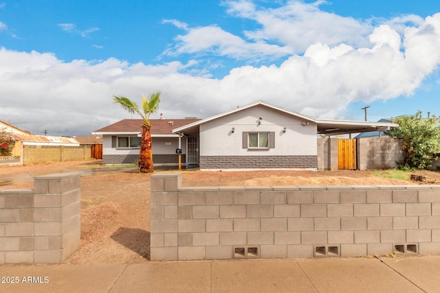 single story home featuring an attached carport, brick siding, and fence