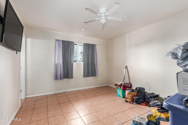 unfurnished room with light tile patterned flooring, baseboards, and a ceiling fan