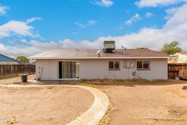 rear view of property with central AC unit and fence